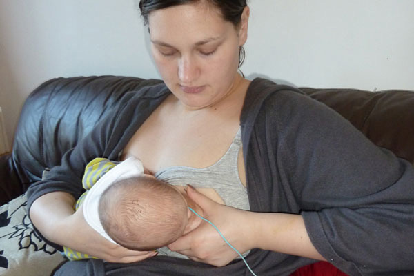 baby breastfeeds in cross cradle position