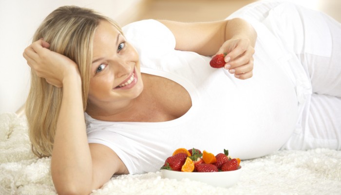 schwangere frau mit frischen früchten
