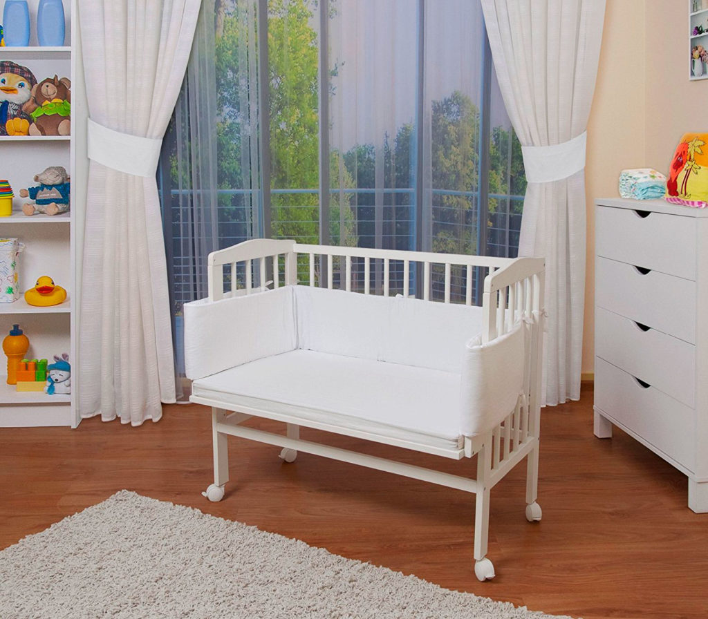 Деревянная кроватка для младенца на колесиках с мягкими накладками на бортиках
