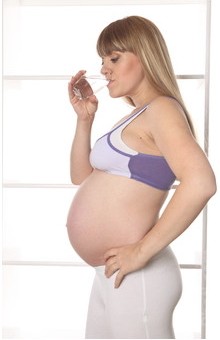 Женщина пьет воду: медикаментозное лечение изжоги у беременных может назначать только врач.