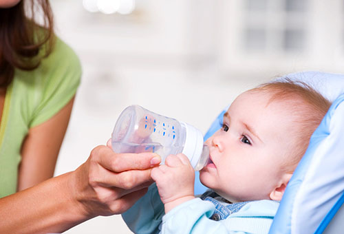 Ребенок пьет воду из бутылочки